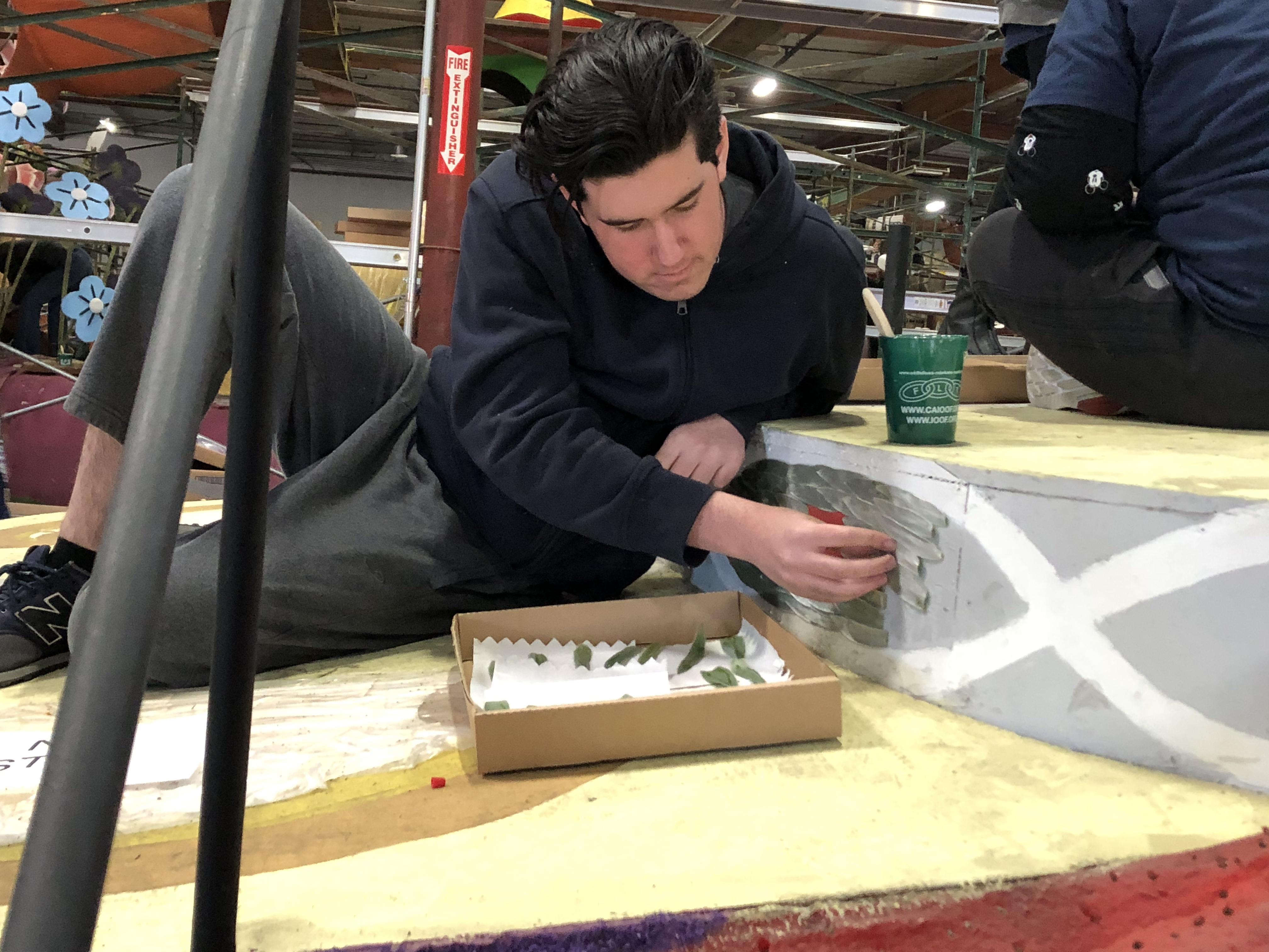 Elijah gluing silverleaf onto a parade float.